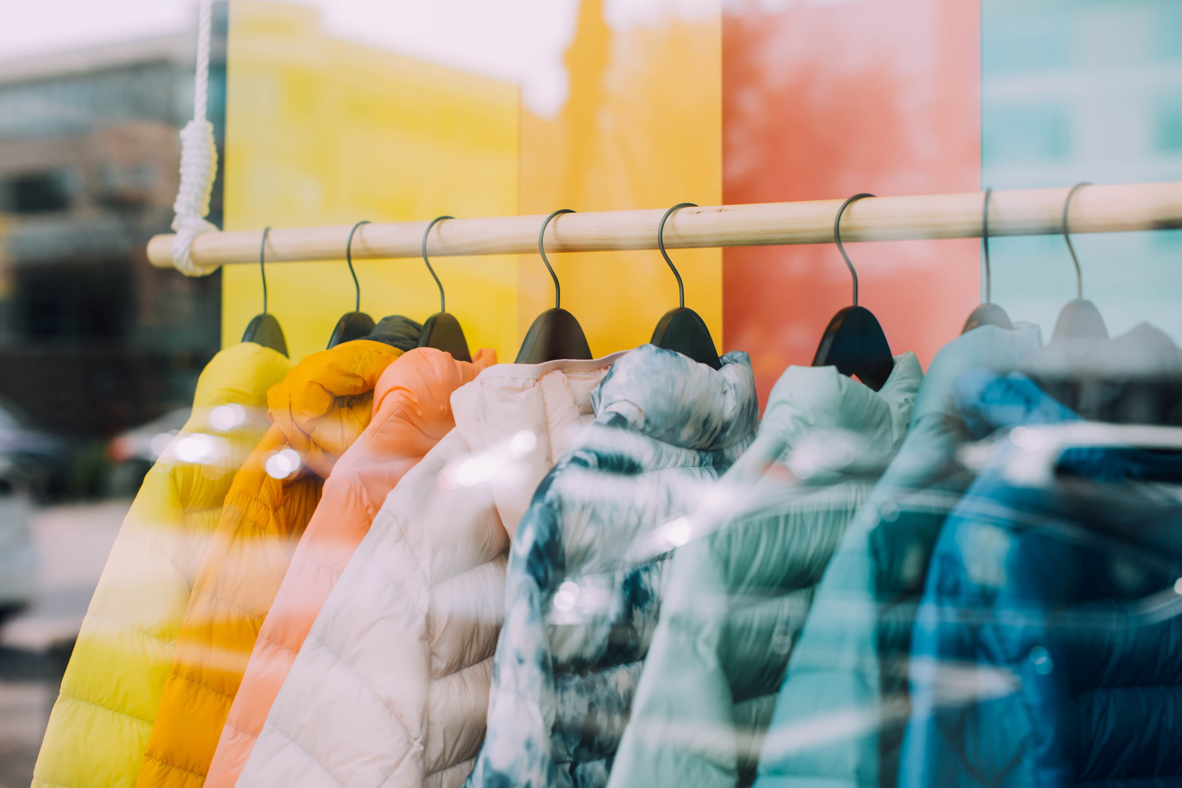 Retail window with jackets of multiple colors for sale.